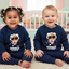 Two children wearing matching blue sweatshirts with 'Astrobeard' design in a nursery.