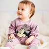 Baby wearing a pink outfit with a Minnie Mouse design on a white background
