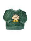 Baby wearing a green sweater with a cartoon design on a blue blanket