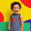 Child wearing a striped outfit with 'Attitude' text against a colorful background