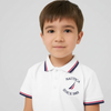 Child wearing a white polo shirt with Nautica logo on a light gray background