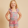 Young girl wearing a floral romper on a beige background