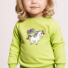 Child wearing a green sweatshirt with a unicorn design and text on a plain background