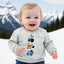 Child wearing a gray sweatshirt with construction vehicle icons against a snowy mountain background