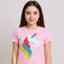 Young girl wearing a pink t-shirt with a unicorn design on a plain background
