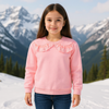 Young girl wearing a pink sweater with a lace collar in a snowy mountain setting