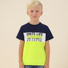 Young boy wearing a two-tone t-shirt with text on a beige background