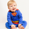 Child wearing a Superman costume on a white background