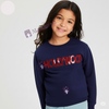 Girl wearing a navy blue sweatshirt with 'HOLLYWOOD' in red sequins on a light gray background
