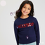 Girl wearing a navy blue sweatshirt with 'HOLLYWOOD' in red sequins on a light gray background