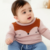 Baby wearing a pink sweater with a fox design on a white background