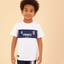 Child wearing a white t-shirt with '4 France' printed on it against a beige background