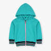 Child wearing a turquoise hoodie with pink zipper on a white background