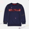 Girl wearing a navy blue sweatshirt with 'HOLLYWOOD' in red sequins on a light gray background
